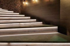 Illuminated staircase with wooden steps and illuminated at night in the interior of a large house